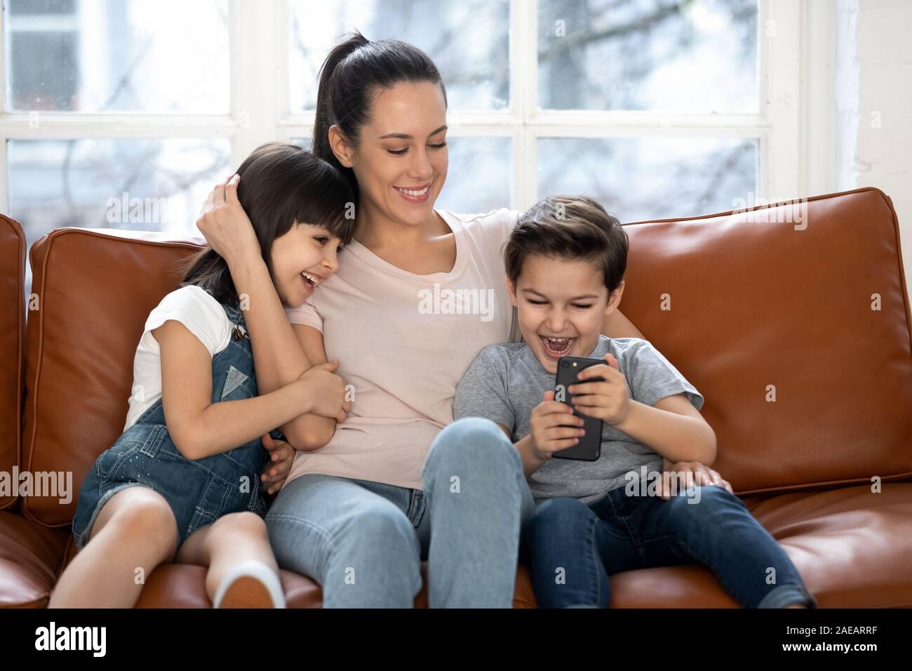 Mère heureuse avec ma petite fille et son fils à l'aide de votre smartphone. Banque D'Images