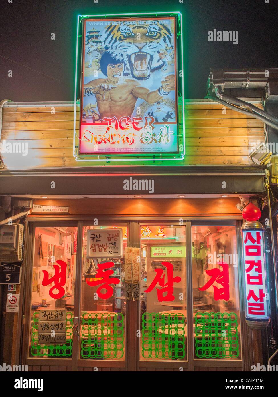 Restaurant, avec film de kung fu advertisment signe, fenêtre avec les caractères chinois rouge, près de la rue de nuit station Gyeongbokgung, Séoul, Corée du Sud. Banque D'Images