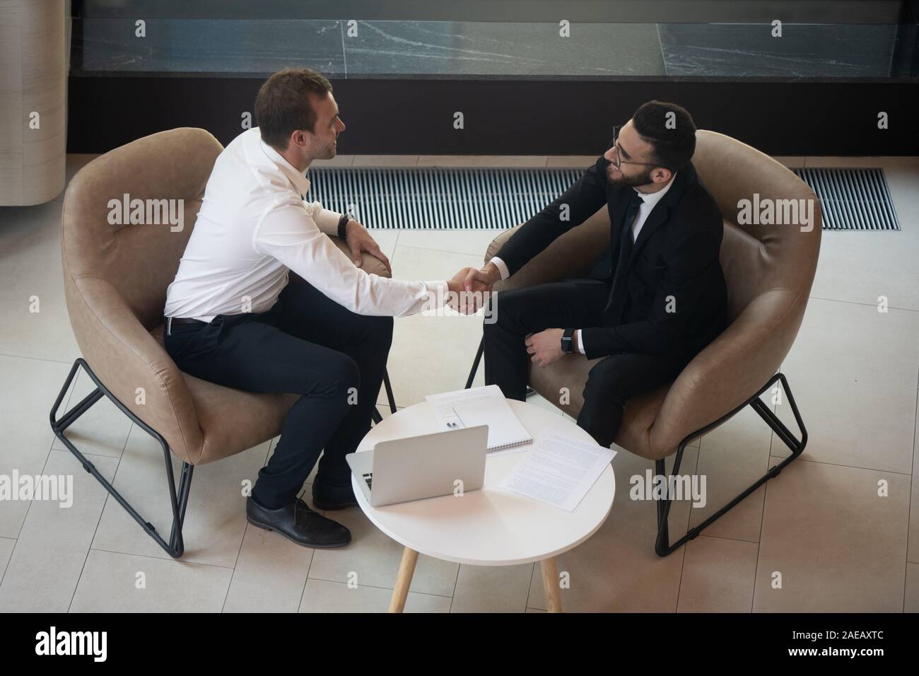 Smiling businessmen handshake faisant accord au briefing Banque D'Images