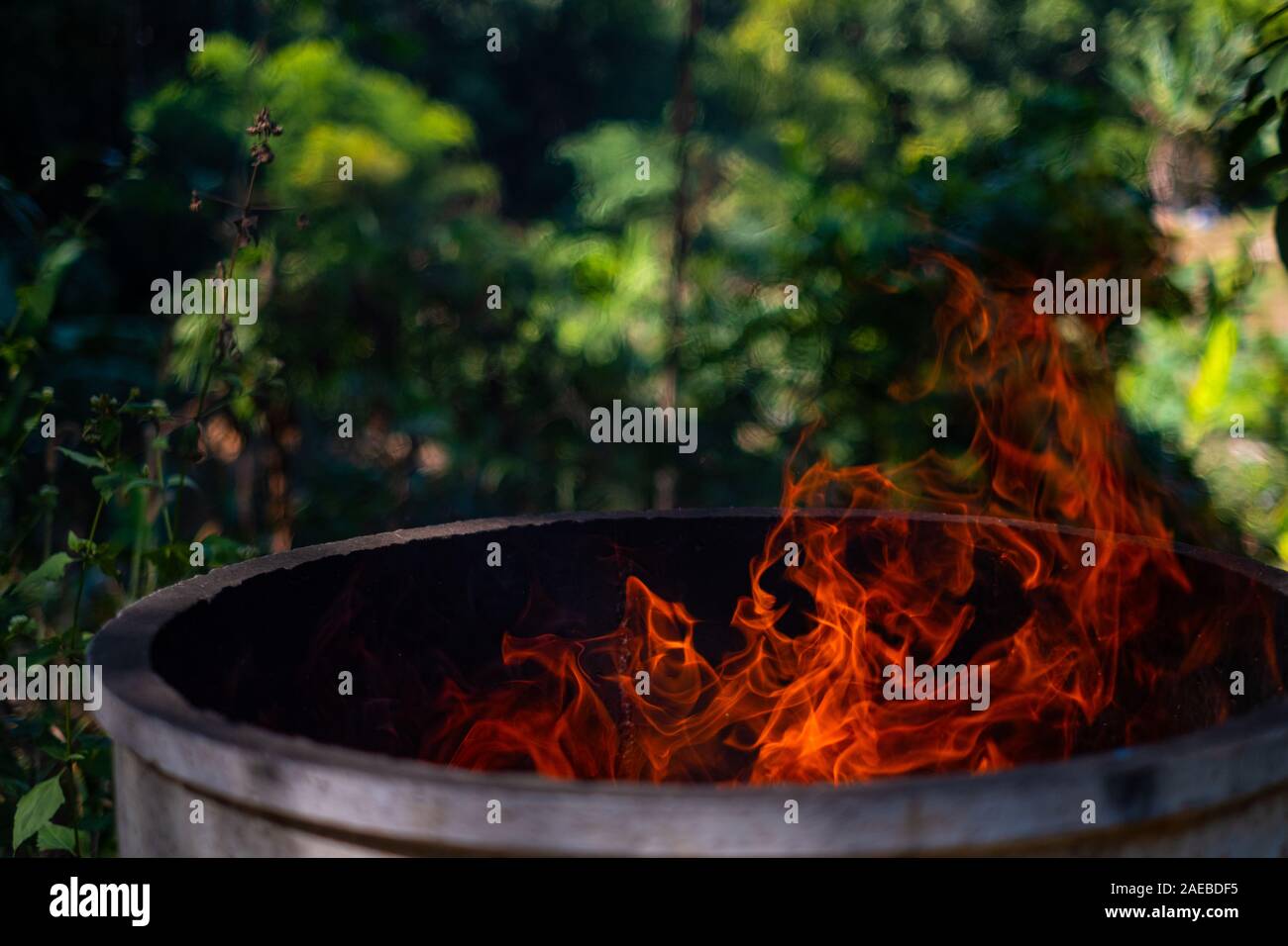 Réservoir de ciment à feu flammes sur fond flou, Burning red hot lieu sparks, Fiery Orange Allumé La projection de particules Banque D'Images