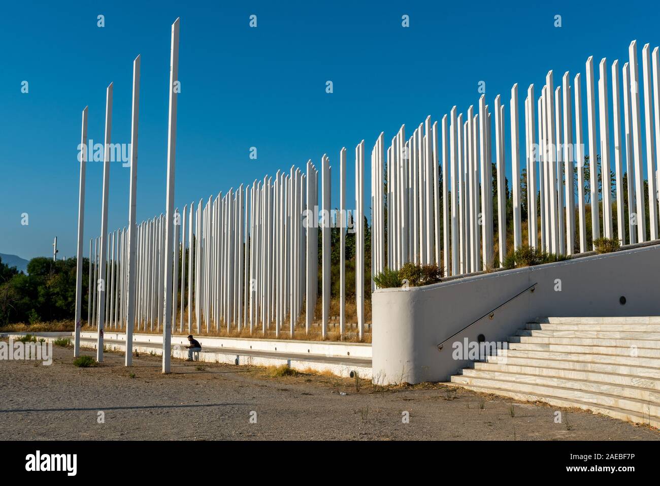 Homme assis seul sur l'étape en face du monument au complexe olympique 2004 à Kifissia, Athènes, Grèce Banque D'Images