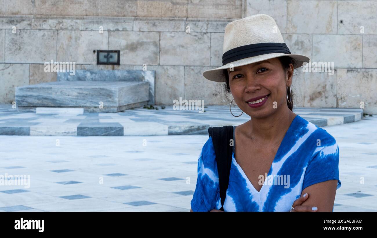 Asian Woman in white fedora smiling at camera sur la Tombe du Soldat inconnu à Athènes, Grèce Banque D'Images