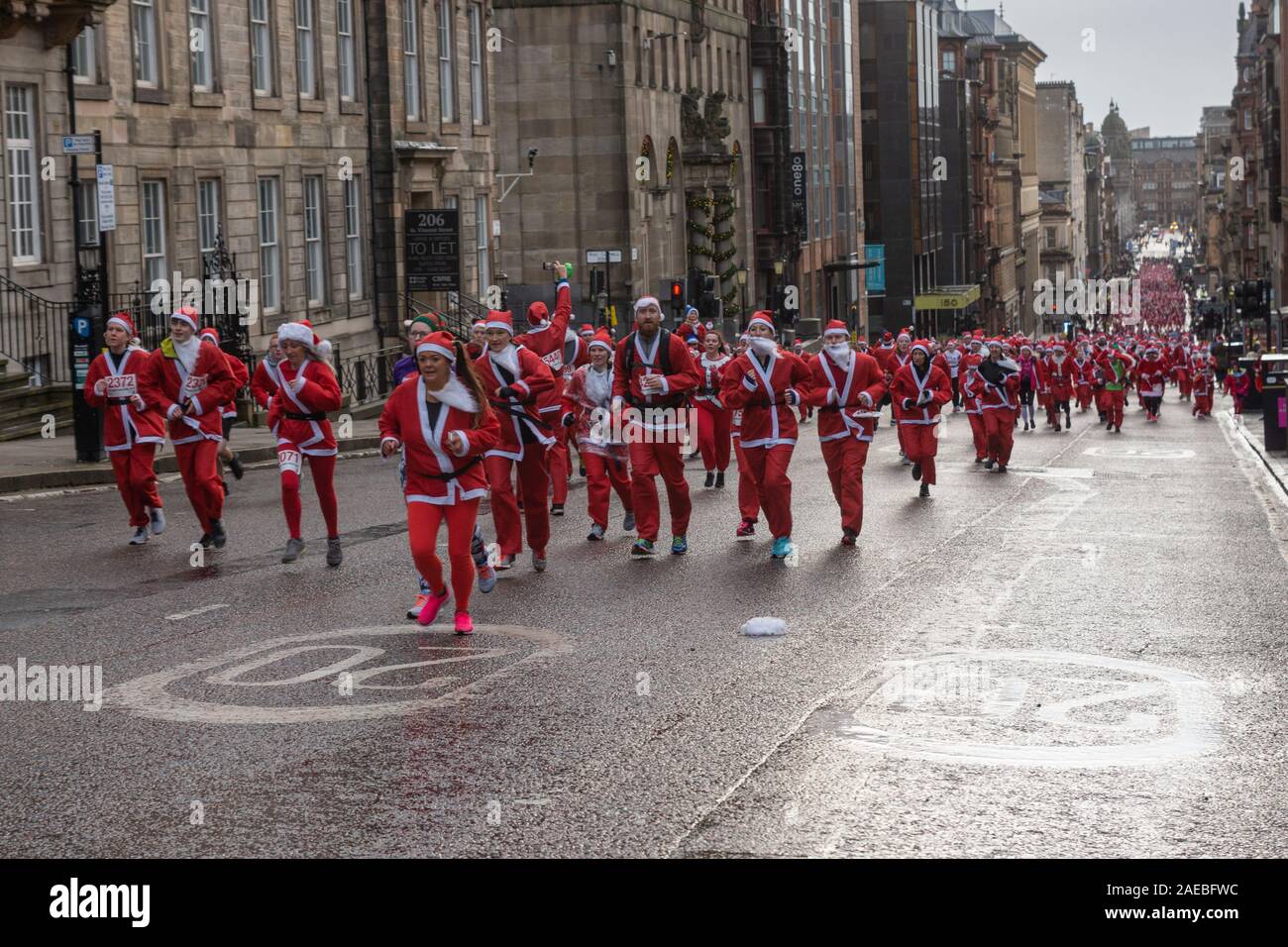 Glasgow, Royaume-Uni. 8 décembre 2019. L'assemblée annuelle 5K Santa Dash de George Square avec environ 8000 personnes habillées en père Noël sous la pluie et la collecte de fonds pour la charité. Crédit : Richard Gass/Alamy Live News Banque D'Images