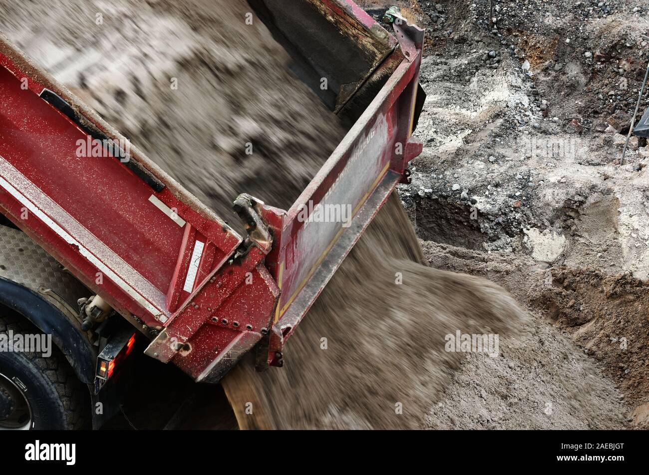 Un camion-benne décharge une cargaison de sable sur un chantier de construction Banque D'Images