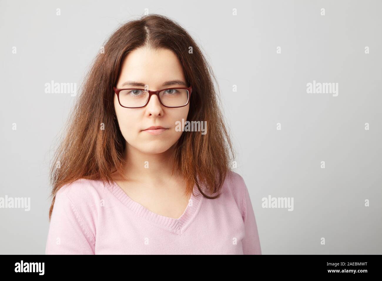 Portrait de la tête et des épaules de jeune femme brune avec des lunettes. Banque D'Images