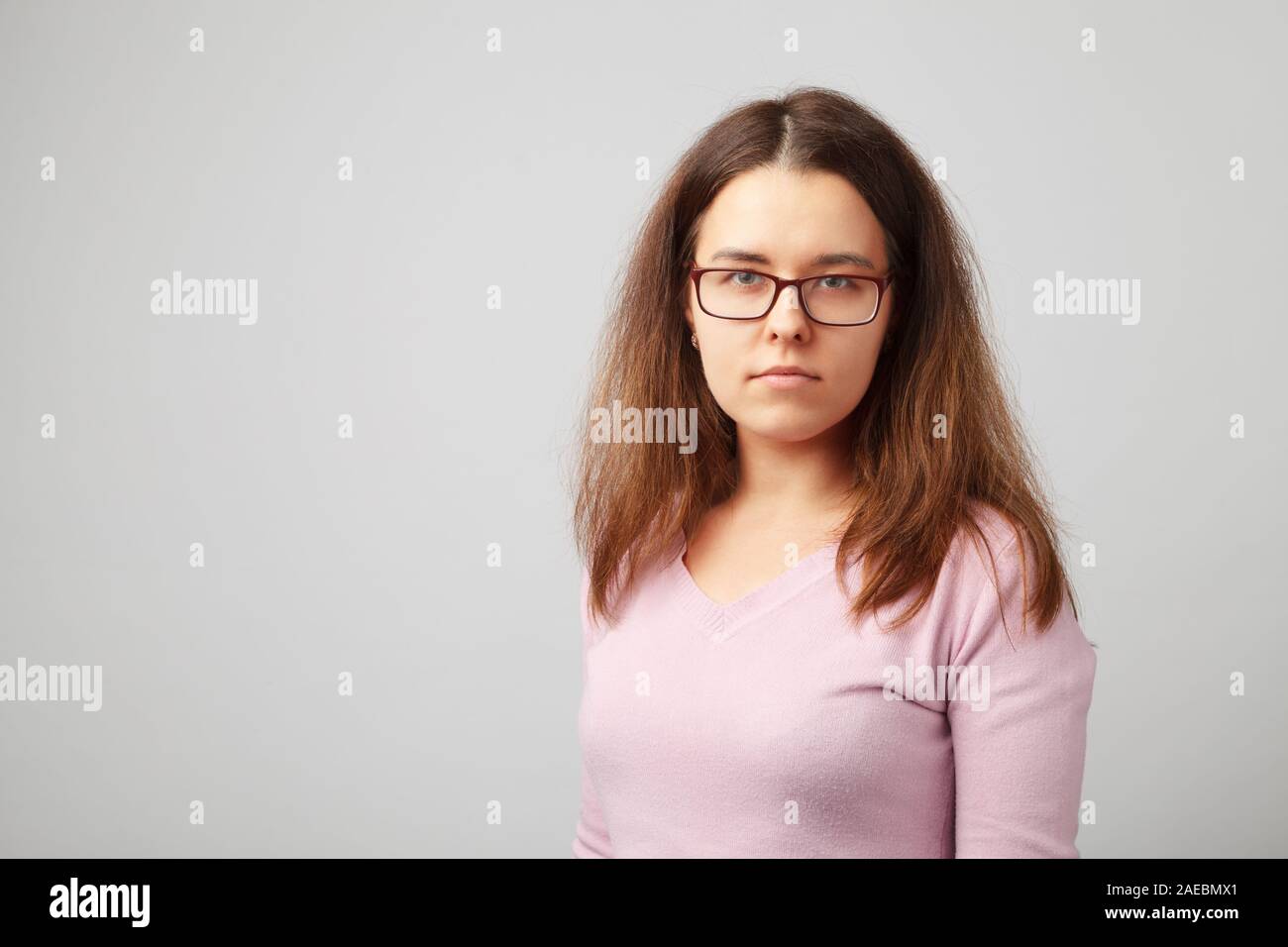 Portrait de la tête et des épaules de jeune femme brune avec des lunettes. Banque D'Images