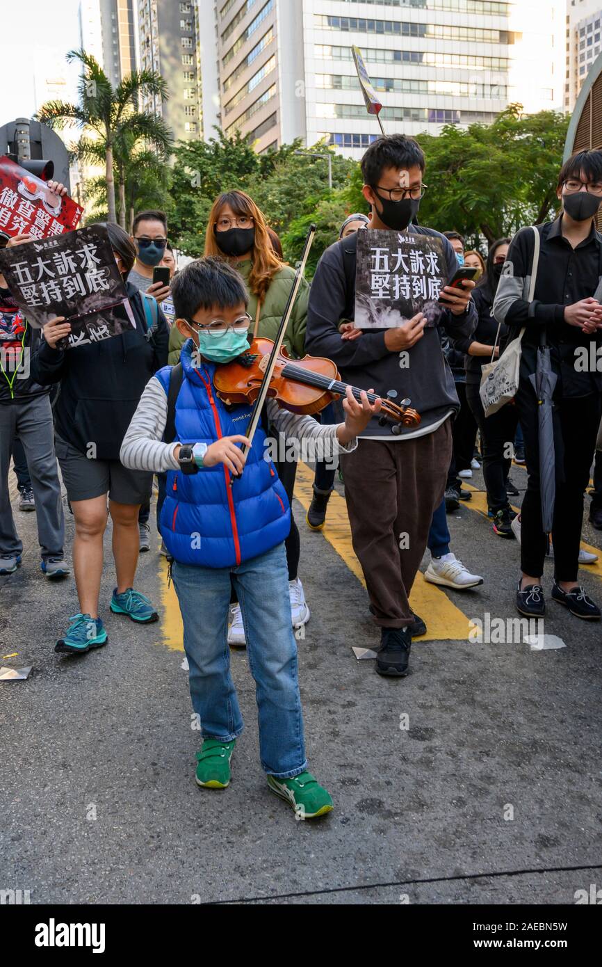 8 décembre 2019 l'île de Hong-Kong. On estime à 800 000 les citoyens de Hong Kong ont pris part à une marche pacifique pour la plupart dans le cadre de l-International-Human Rights-Day-rallye organisé par l'Civil-Human Rights-Front ce jeune garçon a joué l'hymne national de protestation de Hong Kong sur son violon tandis que la foule chantait. Banque D'Images