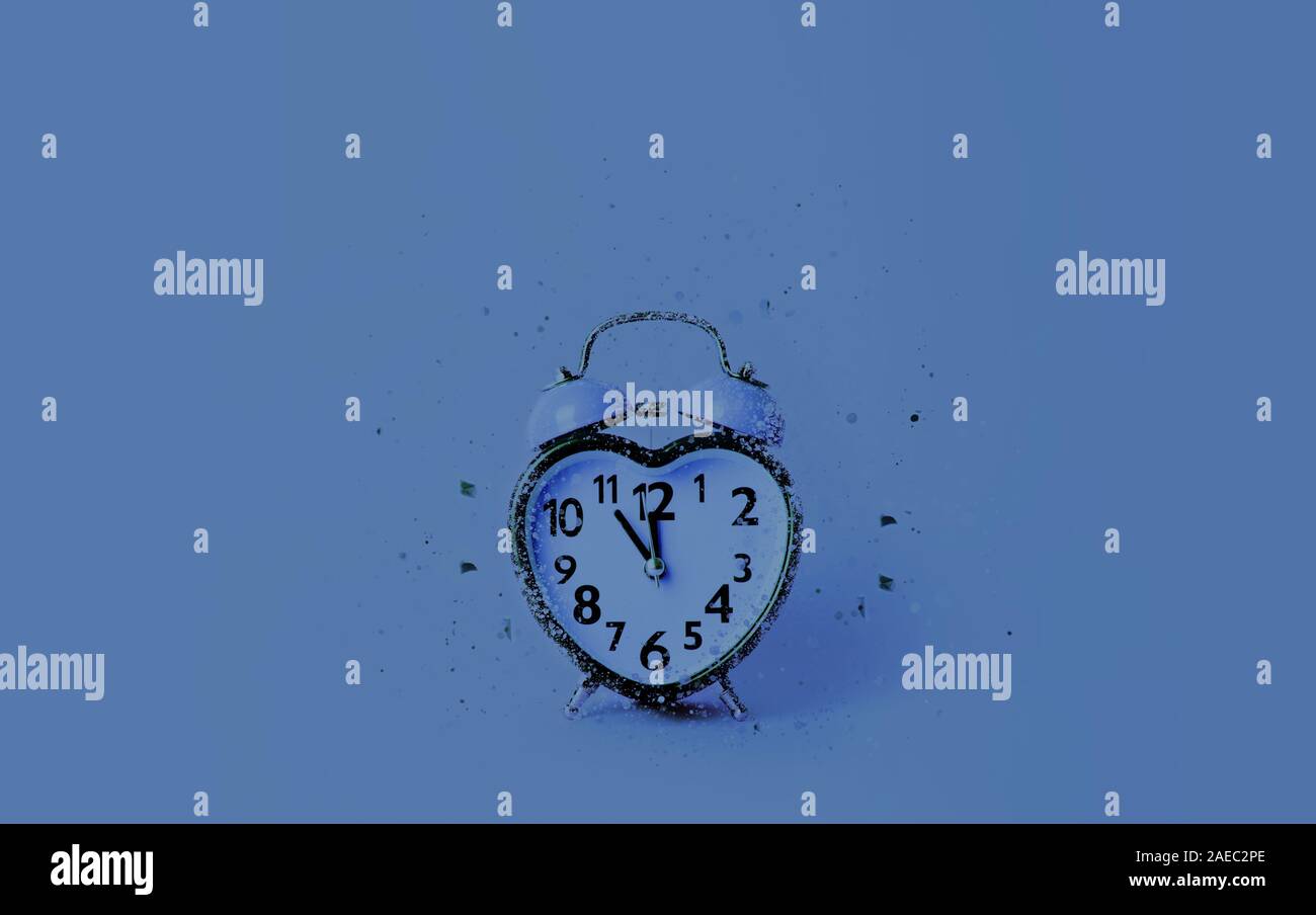 Horloge en forme de coeur sur fond bleu. Banque D'Images