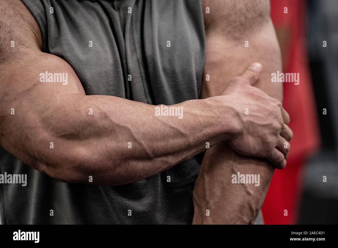 La douleur des blessures de sport concept de l'homme fort avec de grands muscles tenant son coude douloureux après l'endommager pendant un entraînement intensif dans la salle de sport Banque D'Images