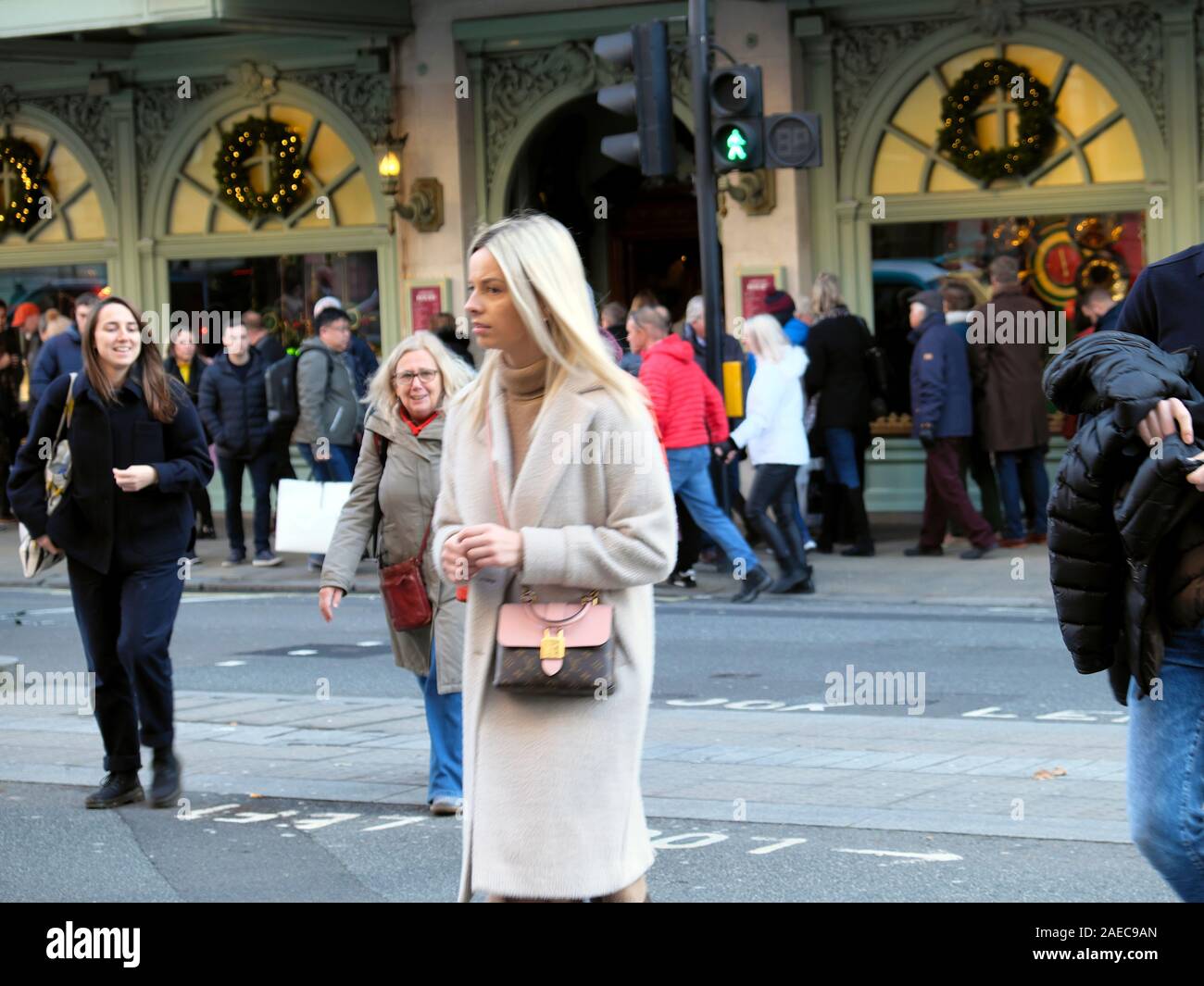 Attractive young woman in winter coat & foule de gens à l'extérieur du magasin Fortnum & Mason à Noël dans Picadilly London England UK KATHY DEWITT Banque D'Images