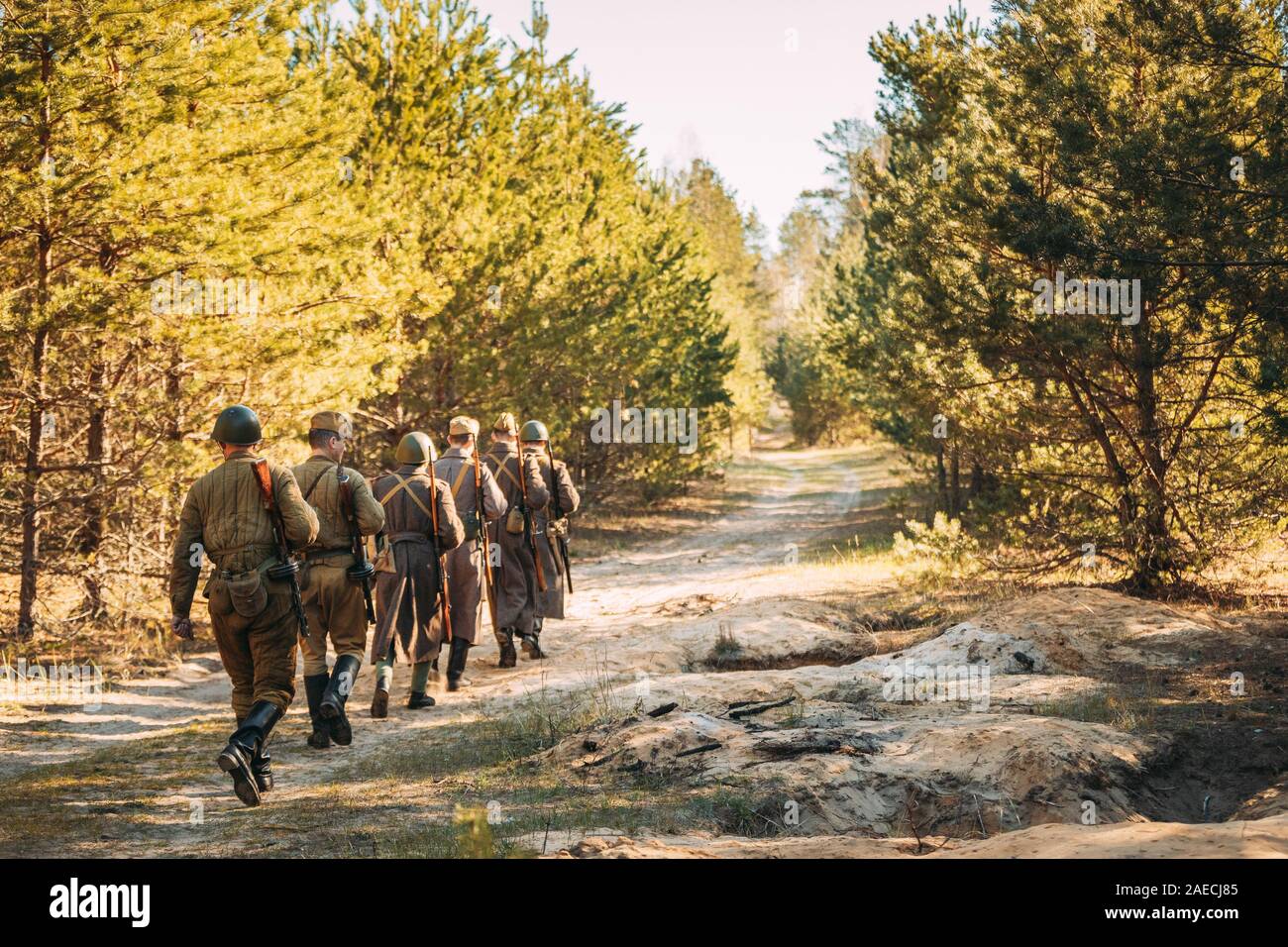 Groupe d'interprètes historiques habillé en russe de l'Armée rouge soviétique, les soldats d'infanterie de la Seconde Guerre mondiale, marchant le long de la route forestière à eté automne Saison. Banque D'Images