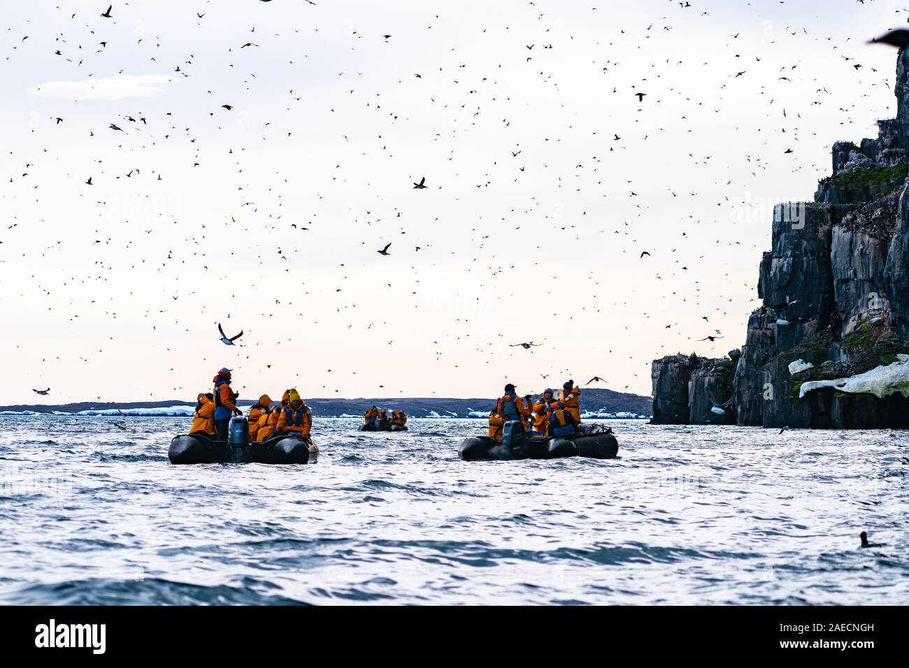 Les passagers de croisière aventure sur un zodiaque en caoutchouc tour lugubre un iceberg au Spitzberg, Norvège en Juillet Banque D'Images