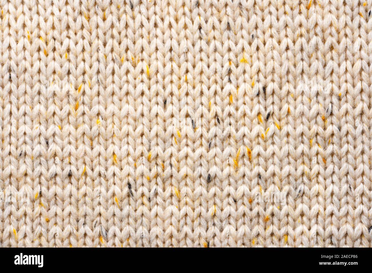 La texture de tissu beige tricot laine entrecoupées de fil jaune. Voir Portrait fond chandail Banque D'Images
