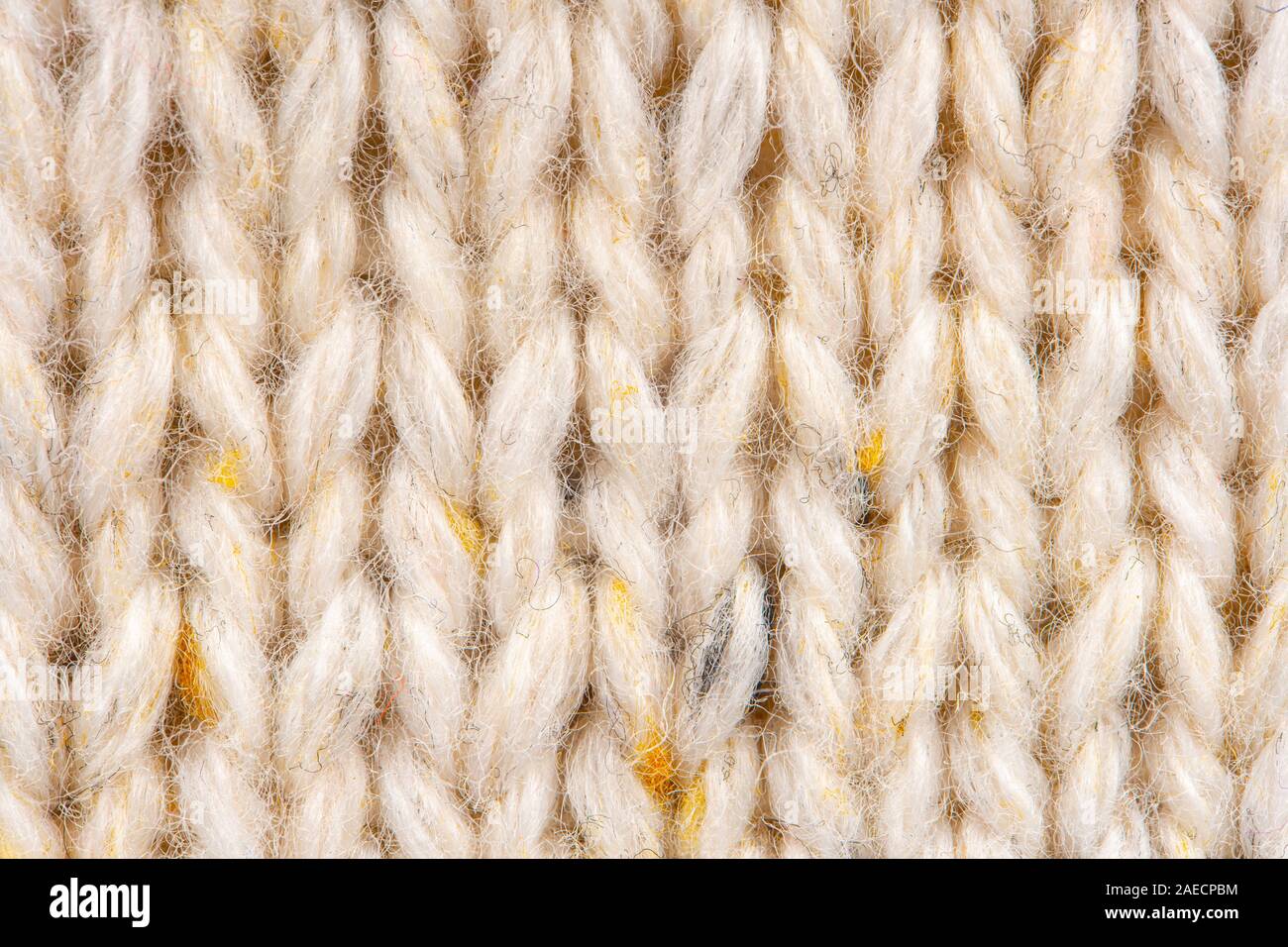 La texture de tissu beige tricot laine entrecoupées de fil jaune. Voir Portrait fond chandail Banque D'Images