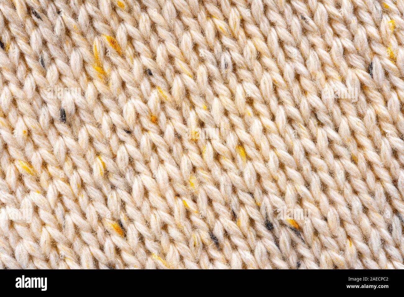 La texture de tissu beige tricot laine entrecoupées de fil jaune. Voir Portrait fond chandail Banque D'Images