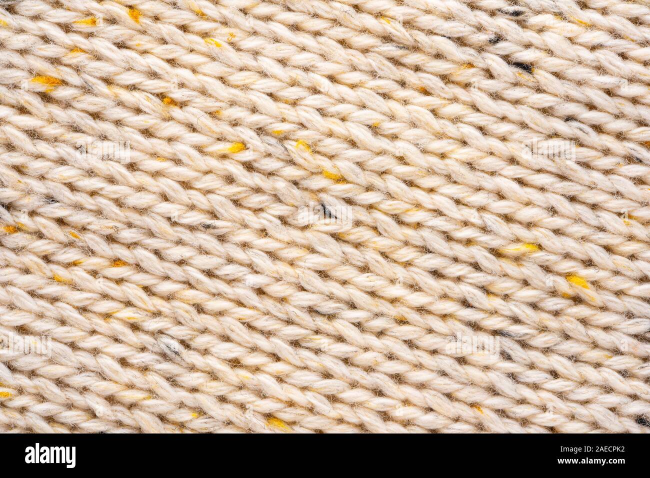 La texture de tissu beige tricot laine entrecoupées de fil jaune. Voir Portrait fond chandail Banque D'Images