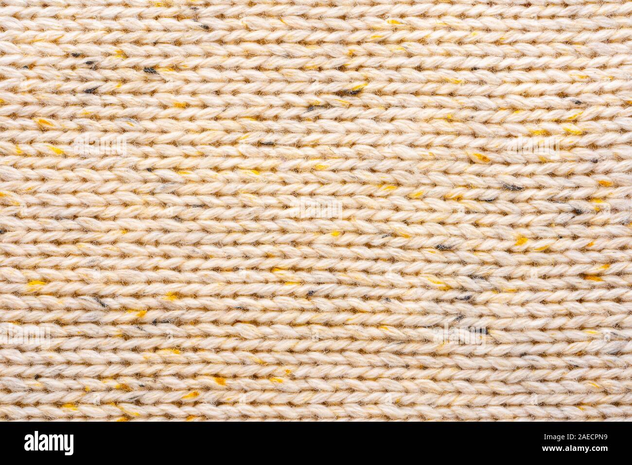 La texture de tissu beige tricot laine entrecoupées de fil jaune. Voir Portrait fond chandail Banque D'Images