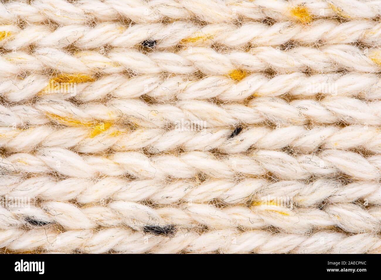 La texture de tissu beige tricot laine entrecoupées de fil jaune. Voir Portrait fond chandail Banque D'Images