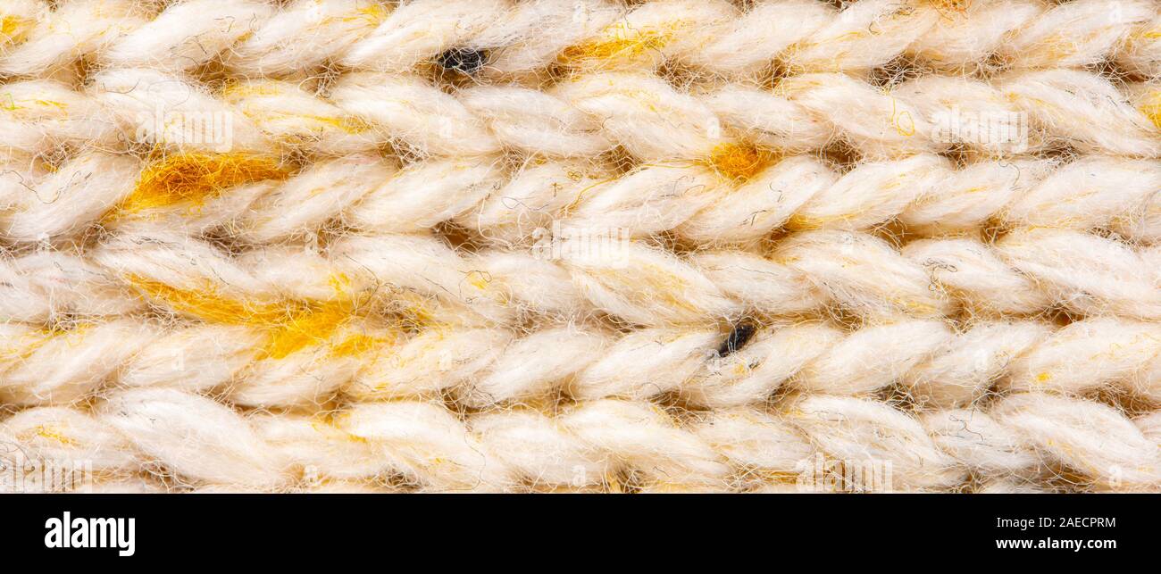 La texture de tissu beige tricot laine entrecoupées de fil jaune. Voir Portrait fond chandail Banque D'Images