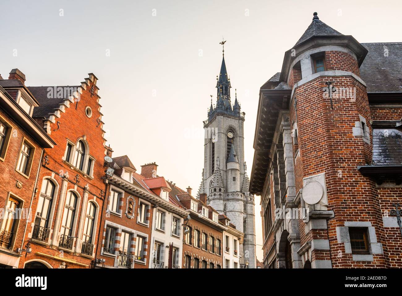 Haut clocher médiéval qui s'élève au-dessus de la rue avec de vieilles maisons européennes, Tournai, Belgique, Région Wallonne Banque D'Images