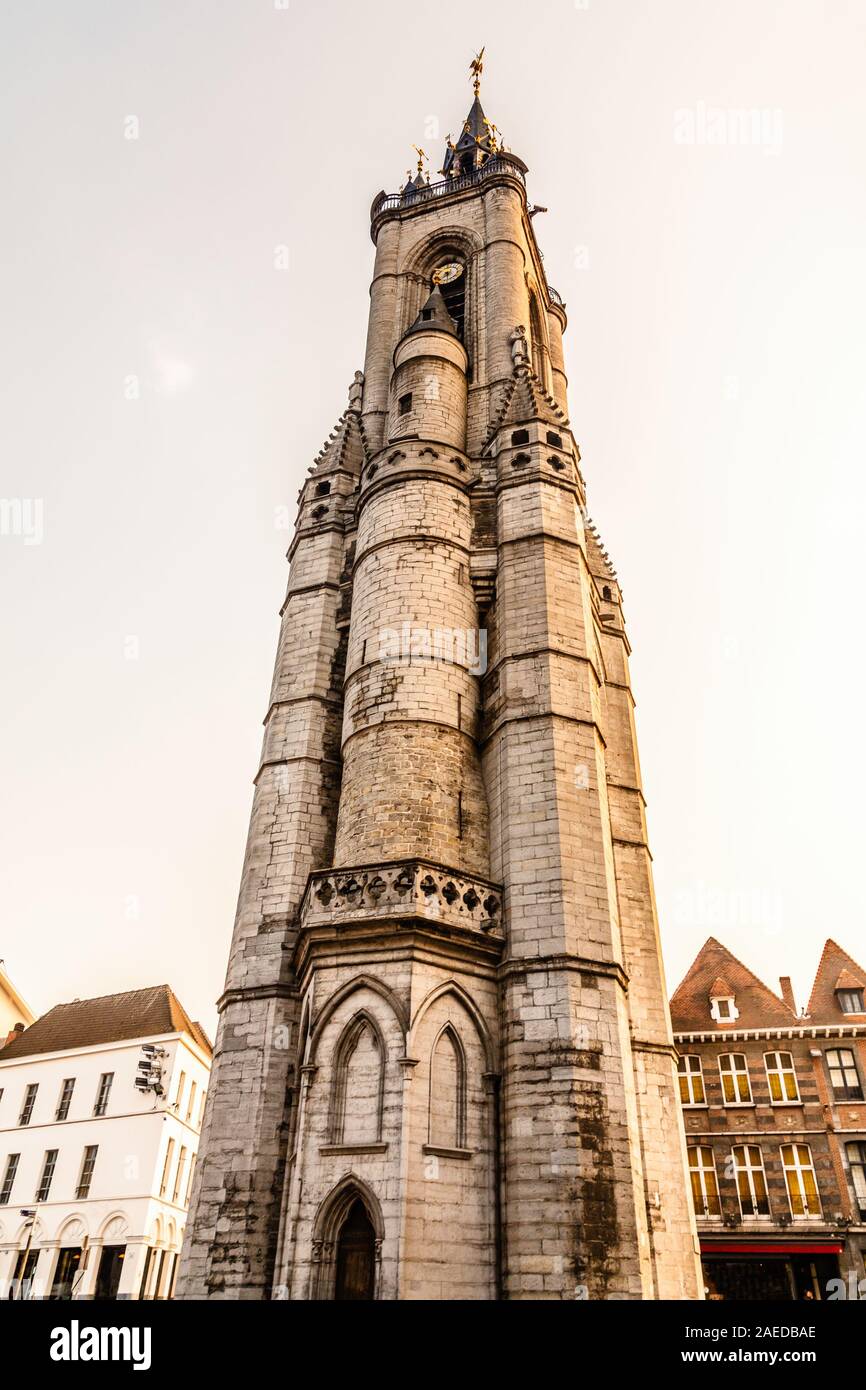 Haut clocher médiéval qui s'élève au-dessus de la rue avec de vieilles maisons européennes, Tournai, Belgique, Région Wallonne Banque D'Images