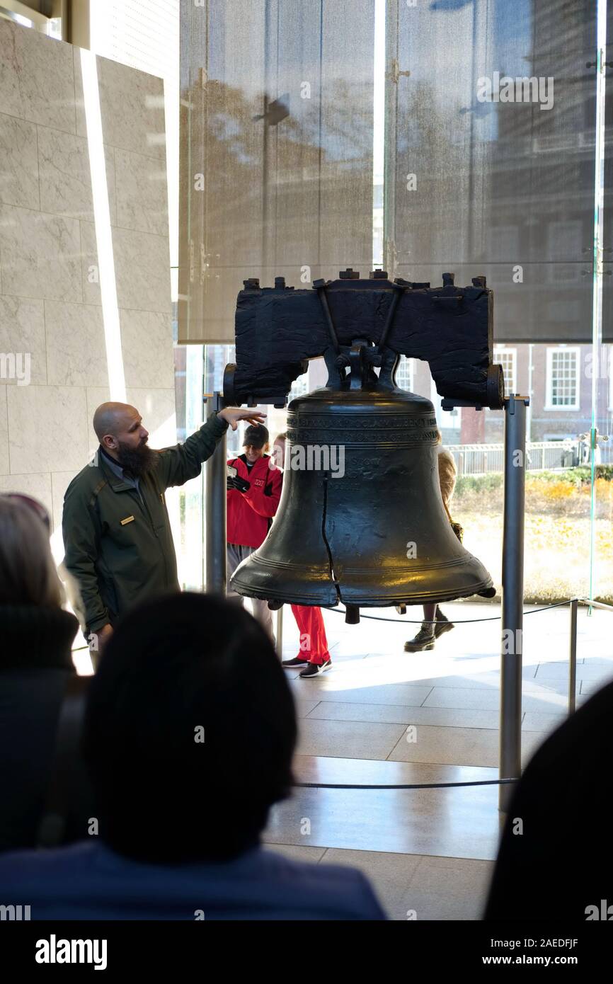 Un garde-parc discute de l'histoire de la Liberty Bell à un groupe de touristes. Le hall de l'indépendance est en arrière-plan, de l'autre côté de la rue. Banque D'Images