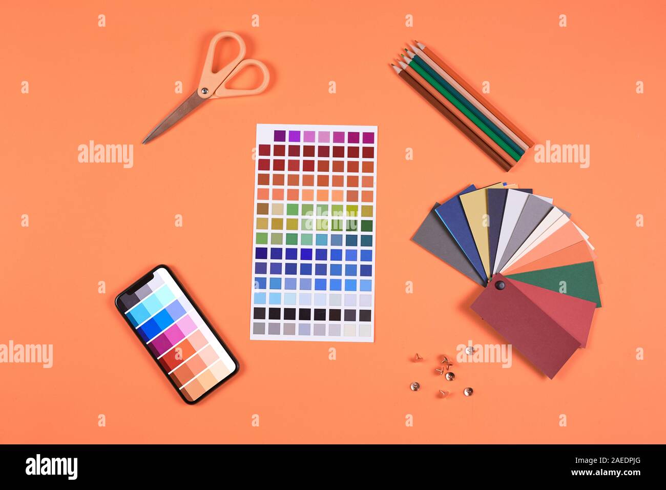 Au-dessus de la télévision laïcs de la palette de nuances et d'échantillons aux concepteurs de travail sur fond orange vif, copy space Banque D'Images