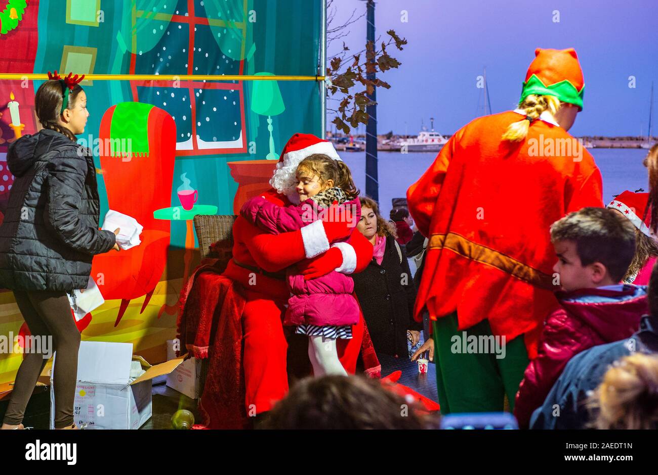 Beaux paysages d'un Santa clauss hugging et donner des cadeaux aux enfants pendant la cérémonie de la foudre de l'arbre de Noël à Chora, île de Skopelos, Grèce Banque D'Images