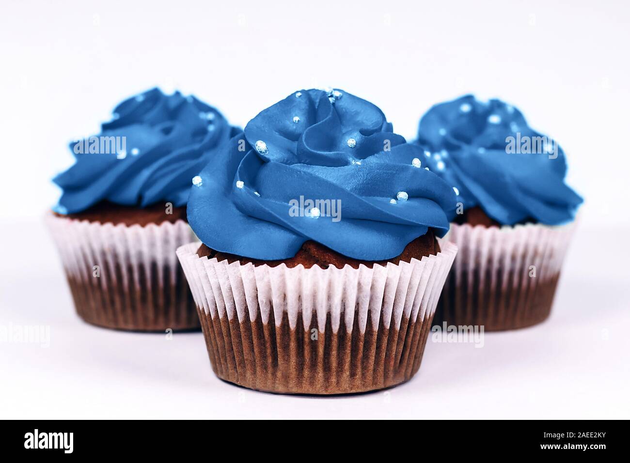 Trois délicieux cupcakes avec du glaçage dans le quartier branché de couleur bleue sur fond blanc isolé. Couleur de l'année 2020 concept. Close-up. Banque D'Images