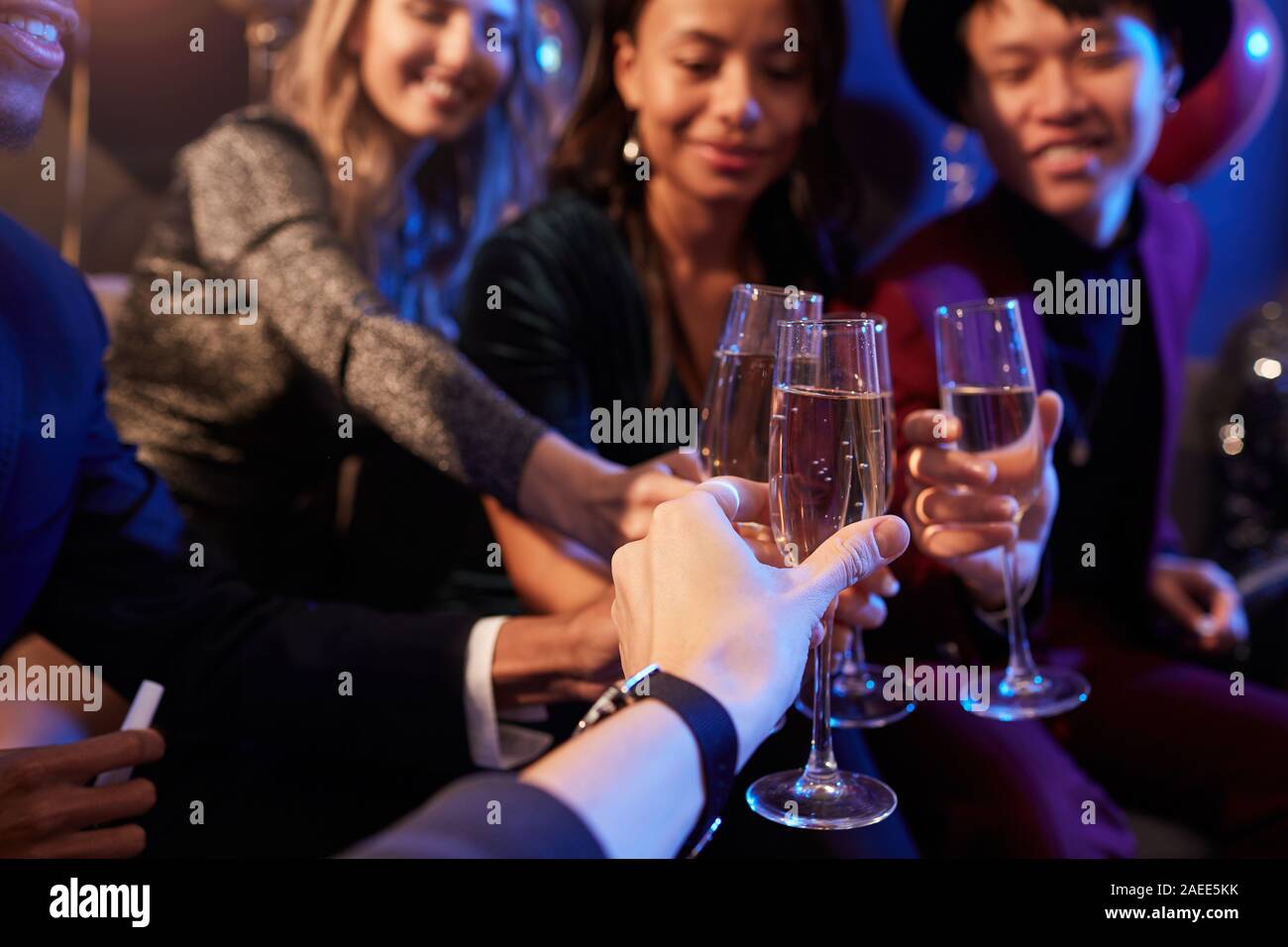 Close up de jeunes élégantes clinking verres de champagne tout en célébrant à partie en discothèque, copy space Banque D'Images