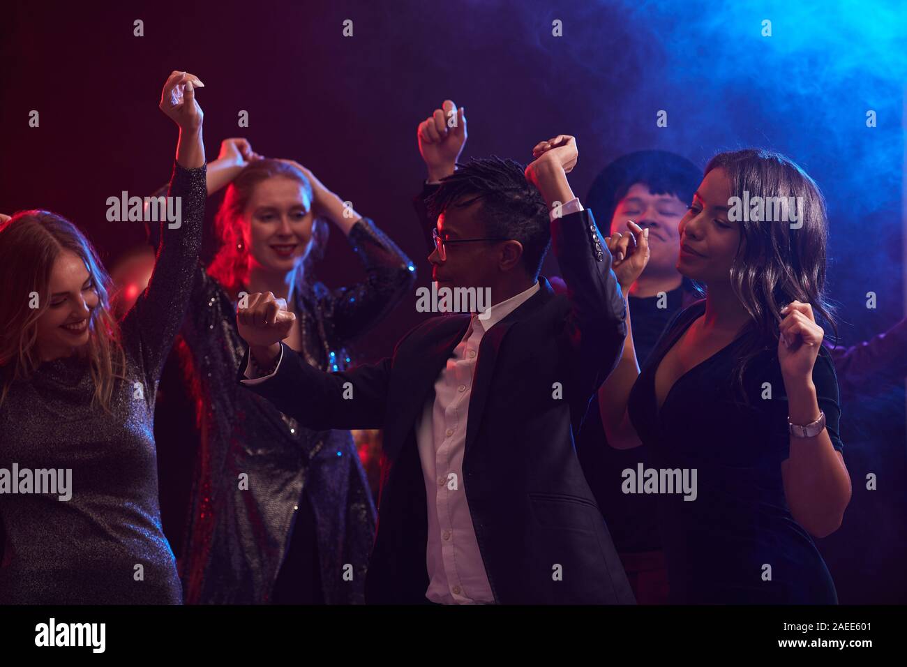 Groupe multi-ethnique de jeunes gens à la mode la danse de smoky discothèque, Afro-américain en premier plan, copy space Banque D'Images