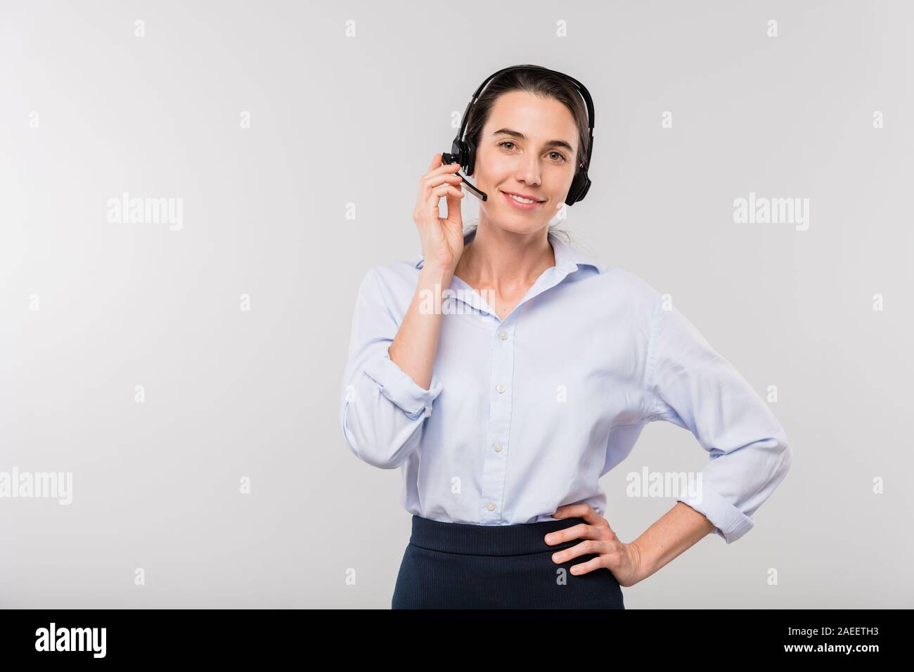 Young smiling businesswoman casque dans la consultation des clients au téléphone Banque D'Images