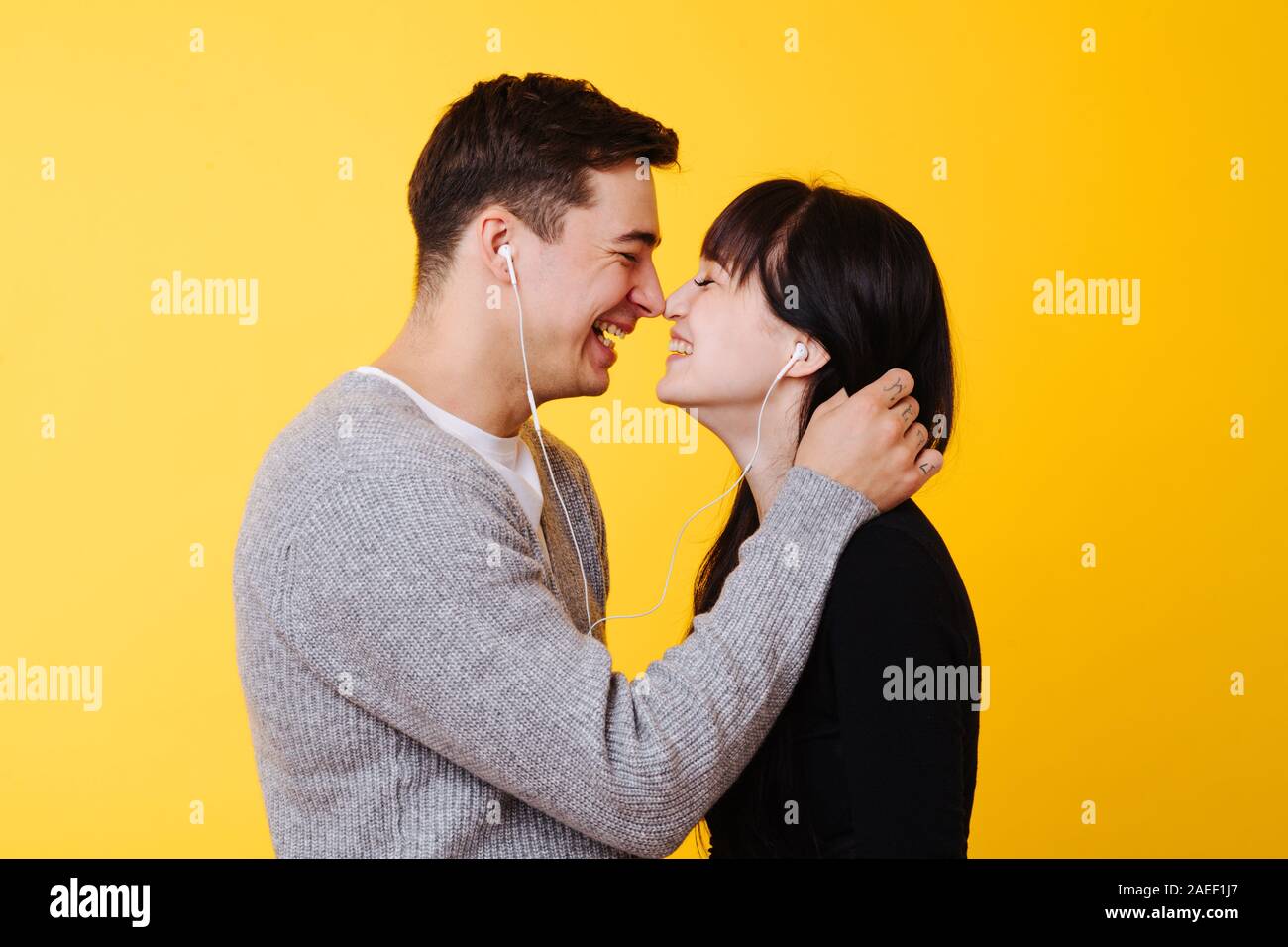 Heureux couple amoureux s'embrasser tout en écoutant le musicover sur jaune Banque D'Images