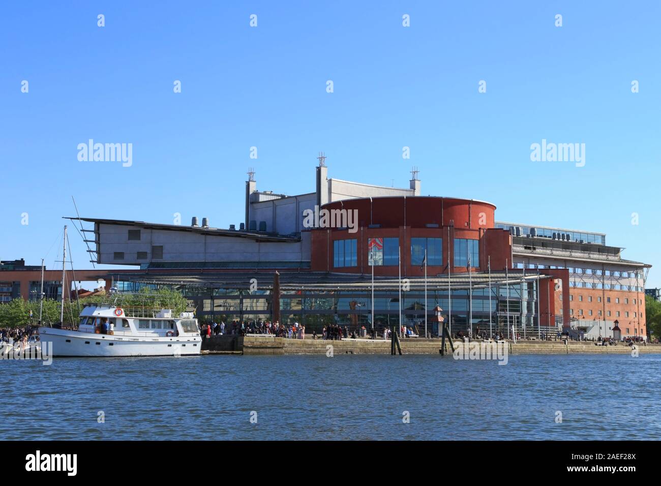 Les gens se rassemblent à l'extérieur de l'opéra de Göteborg (Göteborgsoperan) et un bateau blanc se trouve à quai dans le district Lilla Bommen à Göteborg, Suède. Banque D'Images