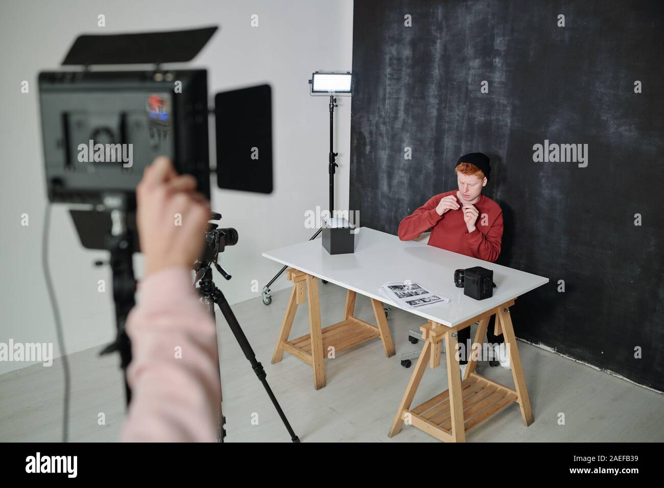 Les jeunes de vlogger casualwear par séance 24 sur fond noir en studio Banque D'Images