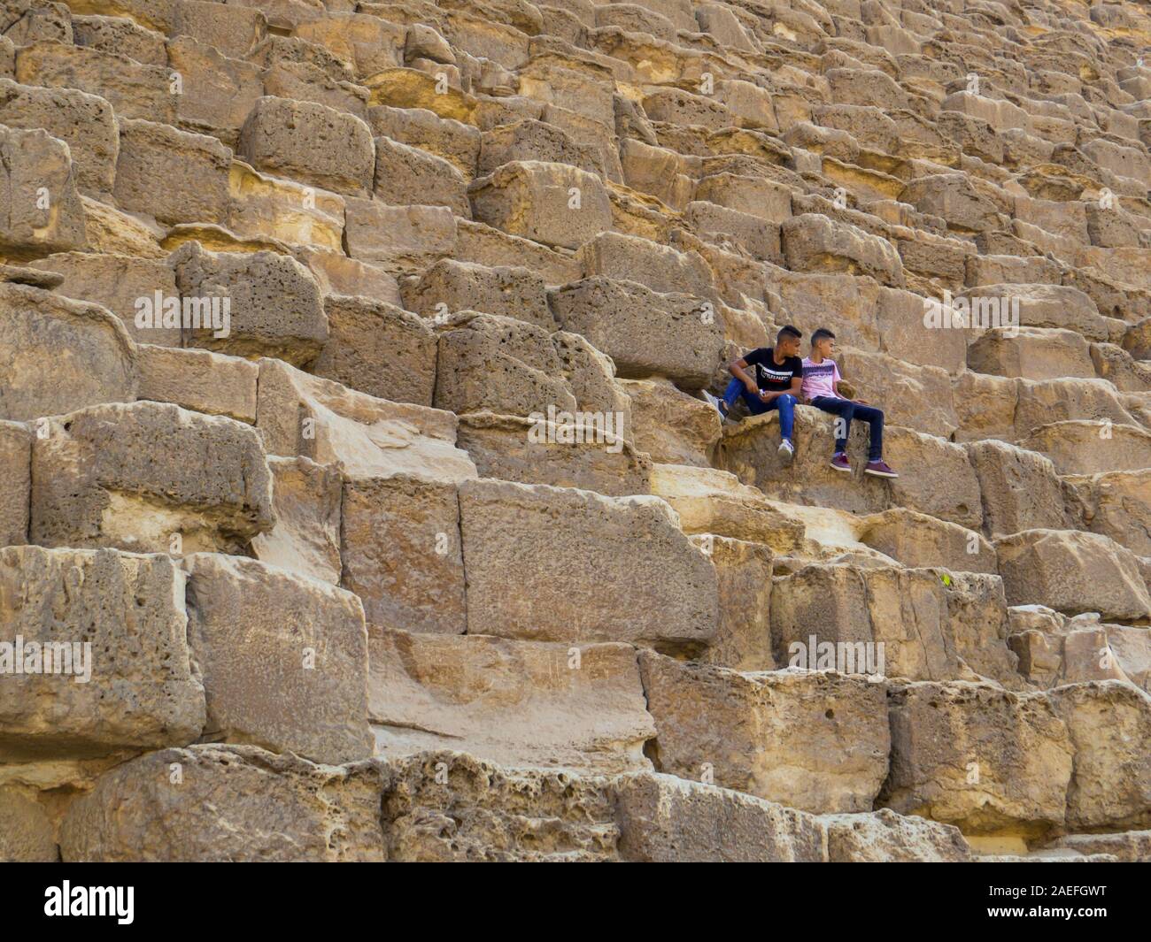 Le Caire, Égypte - 1 novembre, 2019 : les enfants de l'école égyptienne assis sur les blocs de la grande pyramide de Gizeh. Banque D'Images