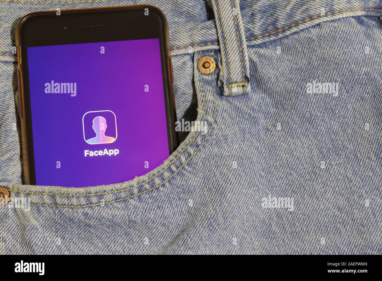 Los Angeles, États-Unis - 10 mars 2020: Téléphone avec le logo de FaceApp dans la poche denim jeans gros plan, éditorial illustratif Banque D'Images