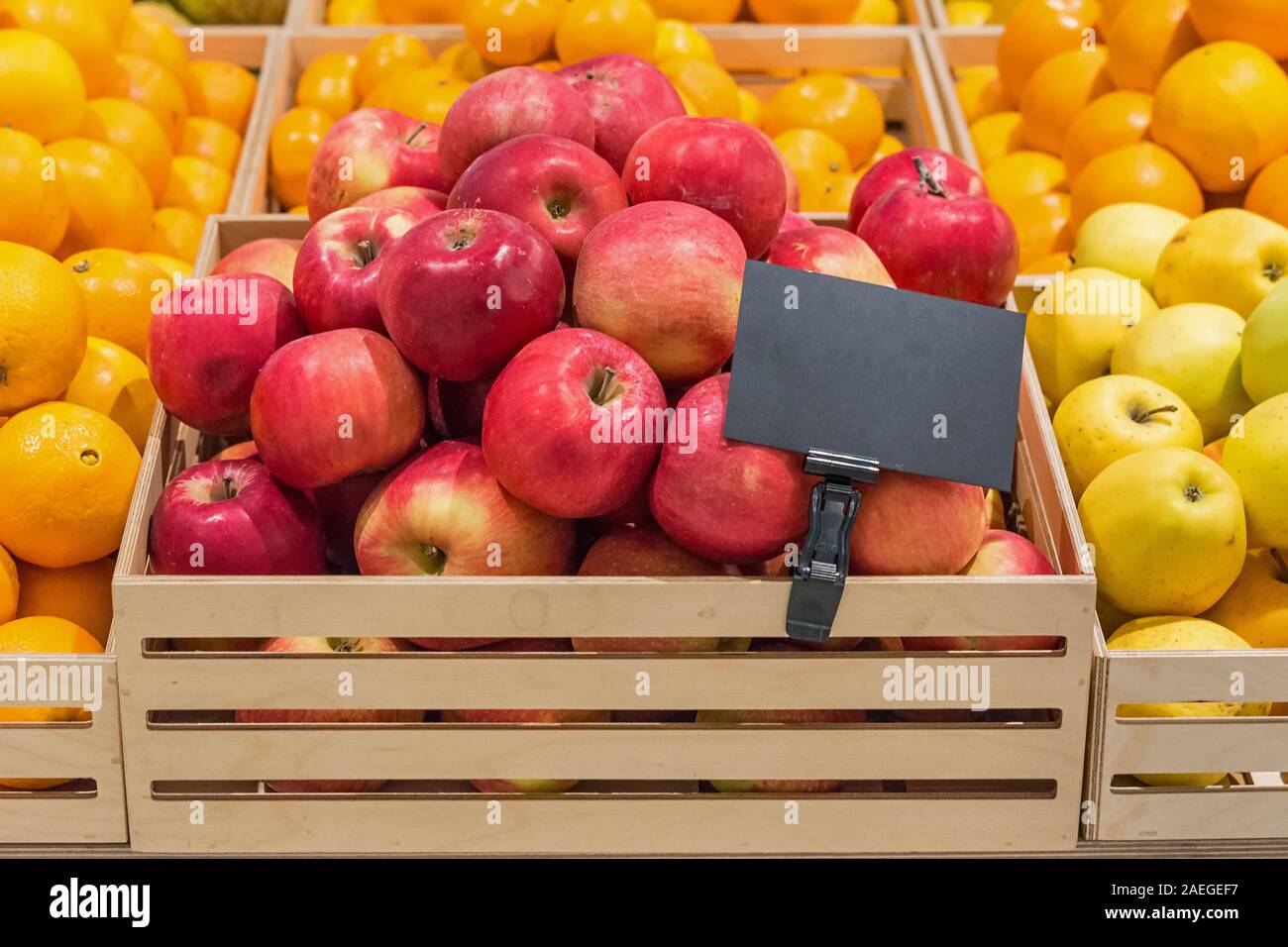 Pommes rouges dans une boîte en bois avec une étiquette de prix Banque D'Images