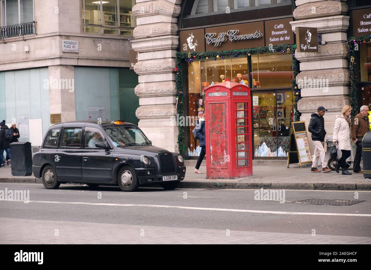 London taxi noir garé à côté de téléphone rouge fort sur Piccadilly street. Londres. Banque D'Images