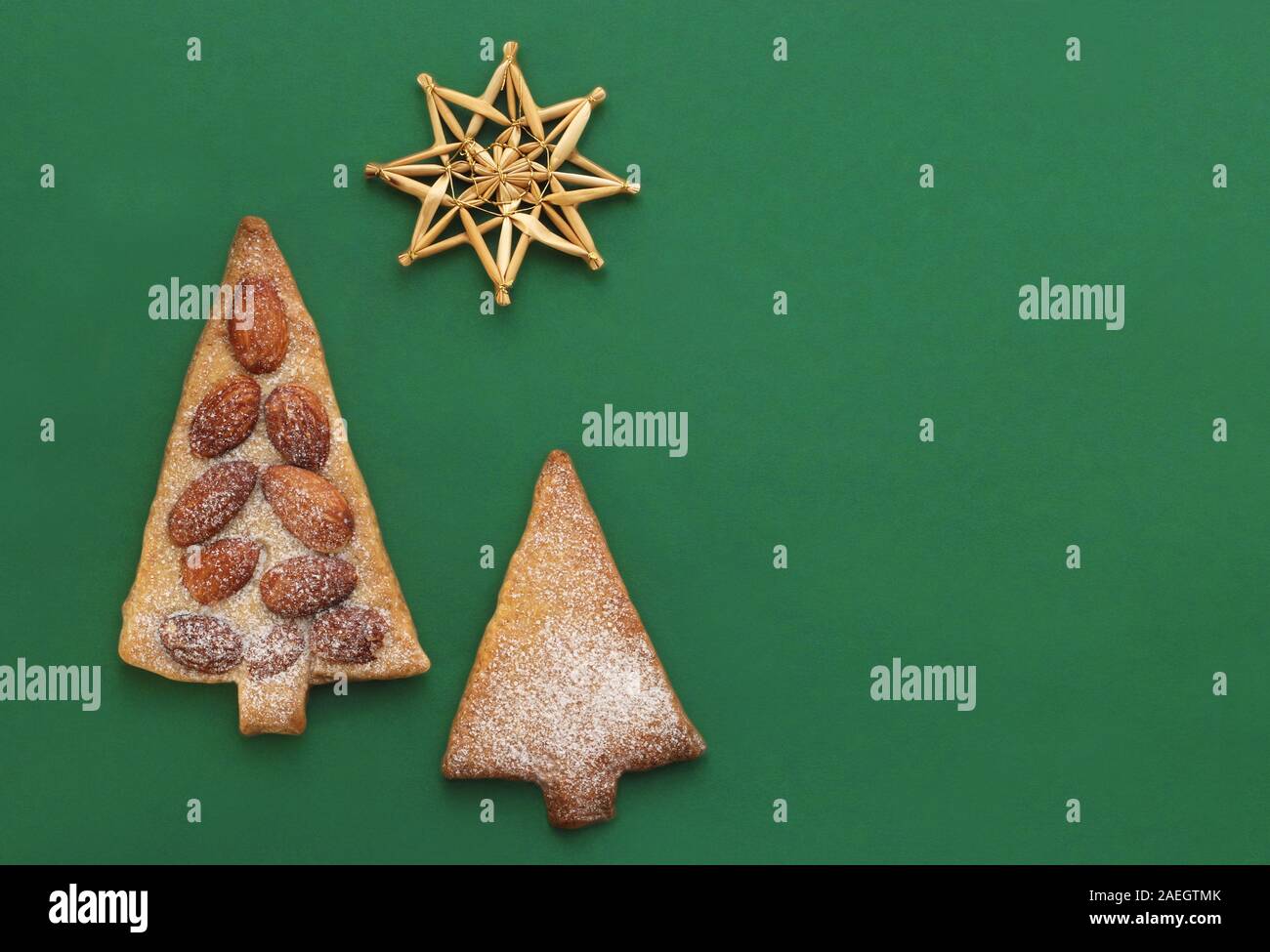 Carte de Noël vert avec étoile avec une paille, les cookies en forme de conifères et copy space Banque D'Images