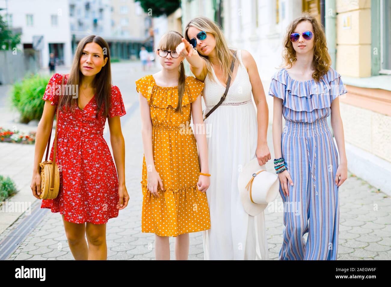 Les jeunes filles et femmes robes colorées du centre-ville à pied, montrant avec le doigt Banque D'Images
