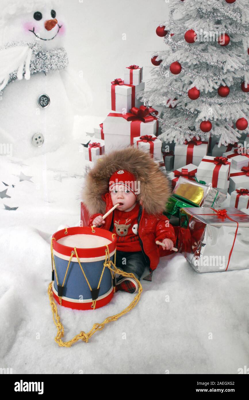 Garçon assis sous l'arbre de Noël avec drum Photo Stock - Alamy