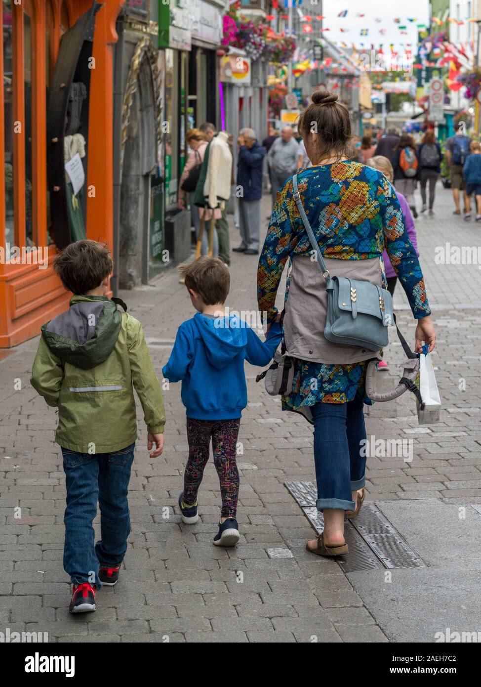 Mère marchant dans la rue du marché avec ses enfants, la ville de Galway, comté de Galway, Irlande Banque D'Images