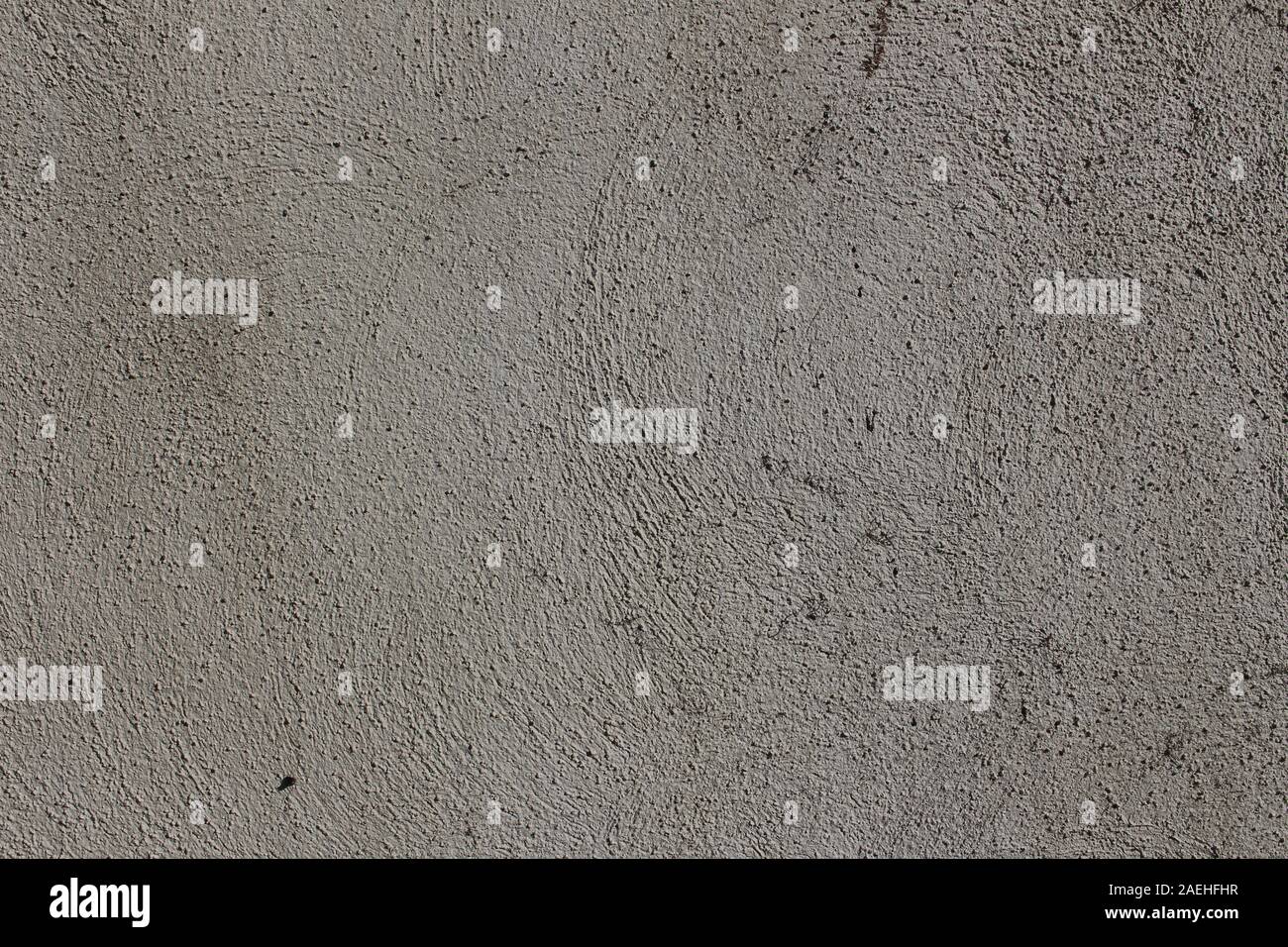 Les lignes courbes en plâtre gris sur un mur de béton Banque D'Images