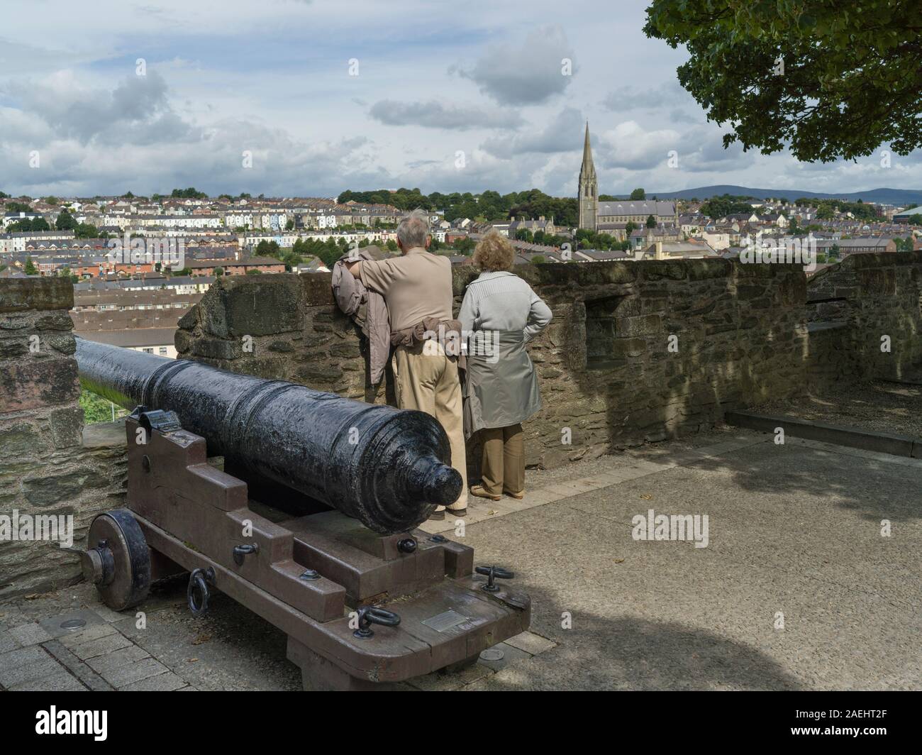 Les touristes debout près de cannon, Derry, Londonderry, République d'Irlande Banque D'Images