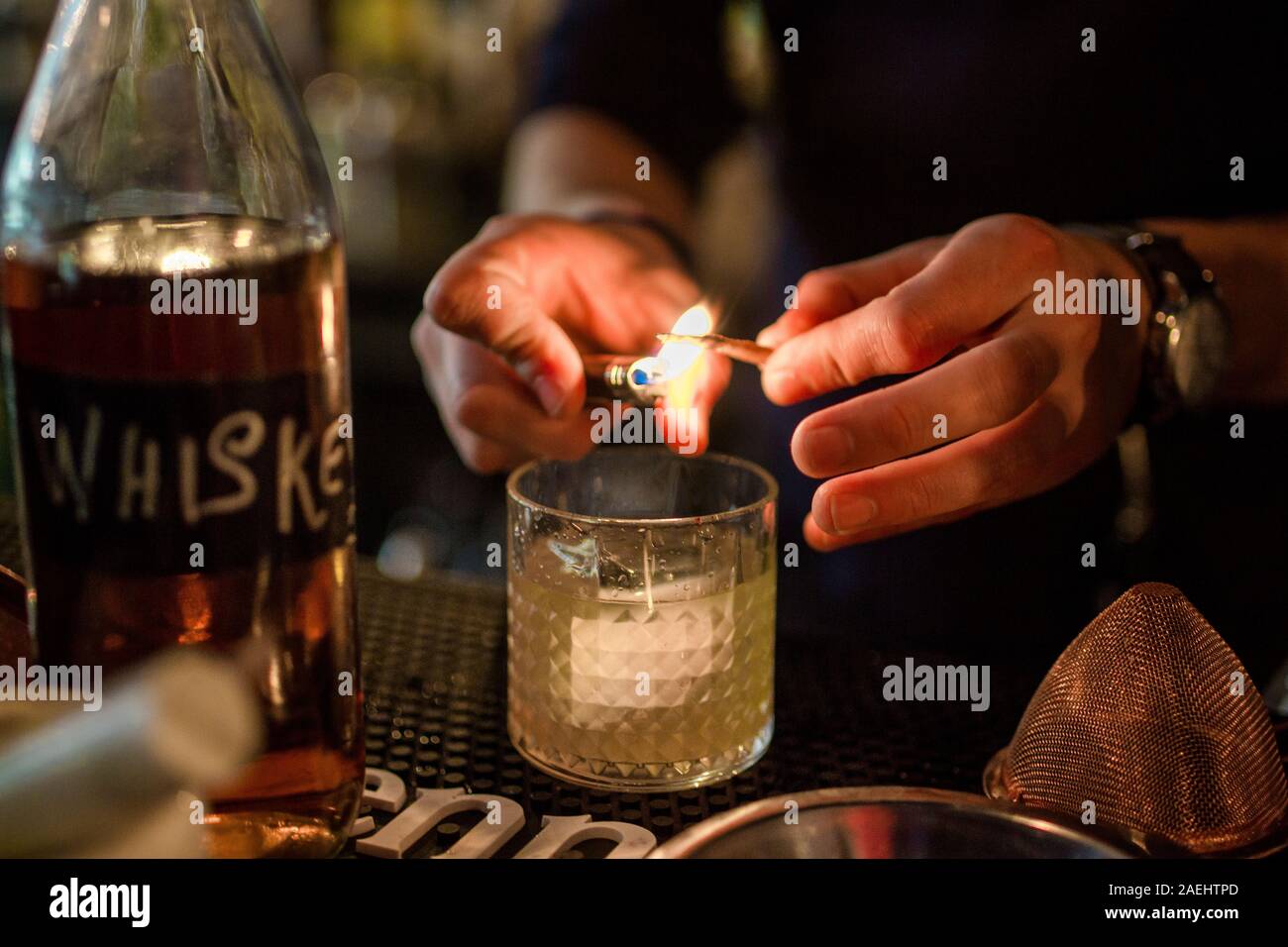 Close up of bartender aromatiques d'éclairage pour un cocktail avec un briquet Banque D'Images