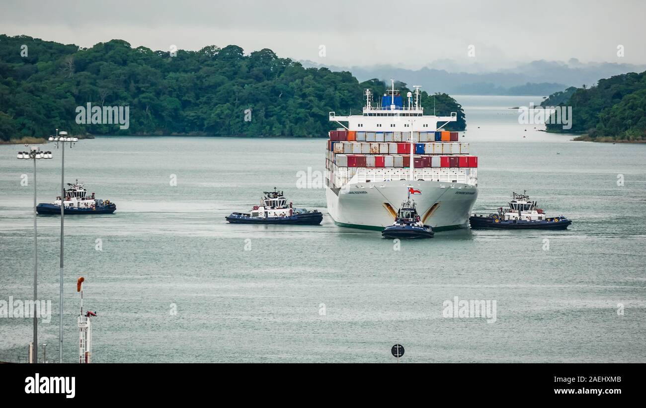 Porte-conteneurs Safmarine Nokwanda (surround) par le Canal de Panama les remorqueurs dans le lac Gatun attendent pour entrer l'Agua Clara serrures. Banque D'Images