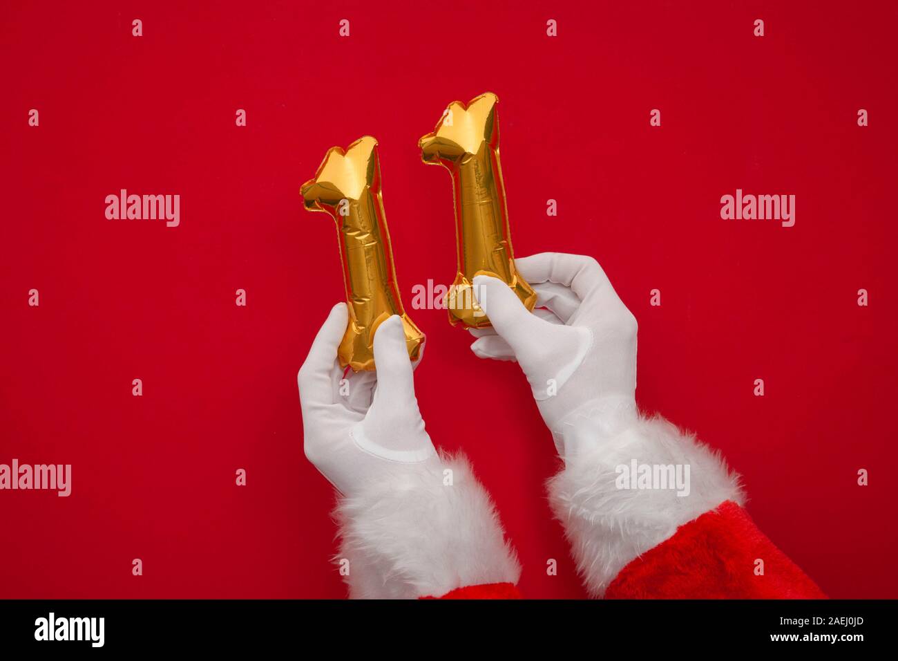 12 jours de Noël. Santa hands holding 11e jour ballon sur fond rouge Banque D'Images