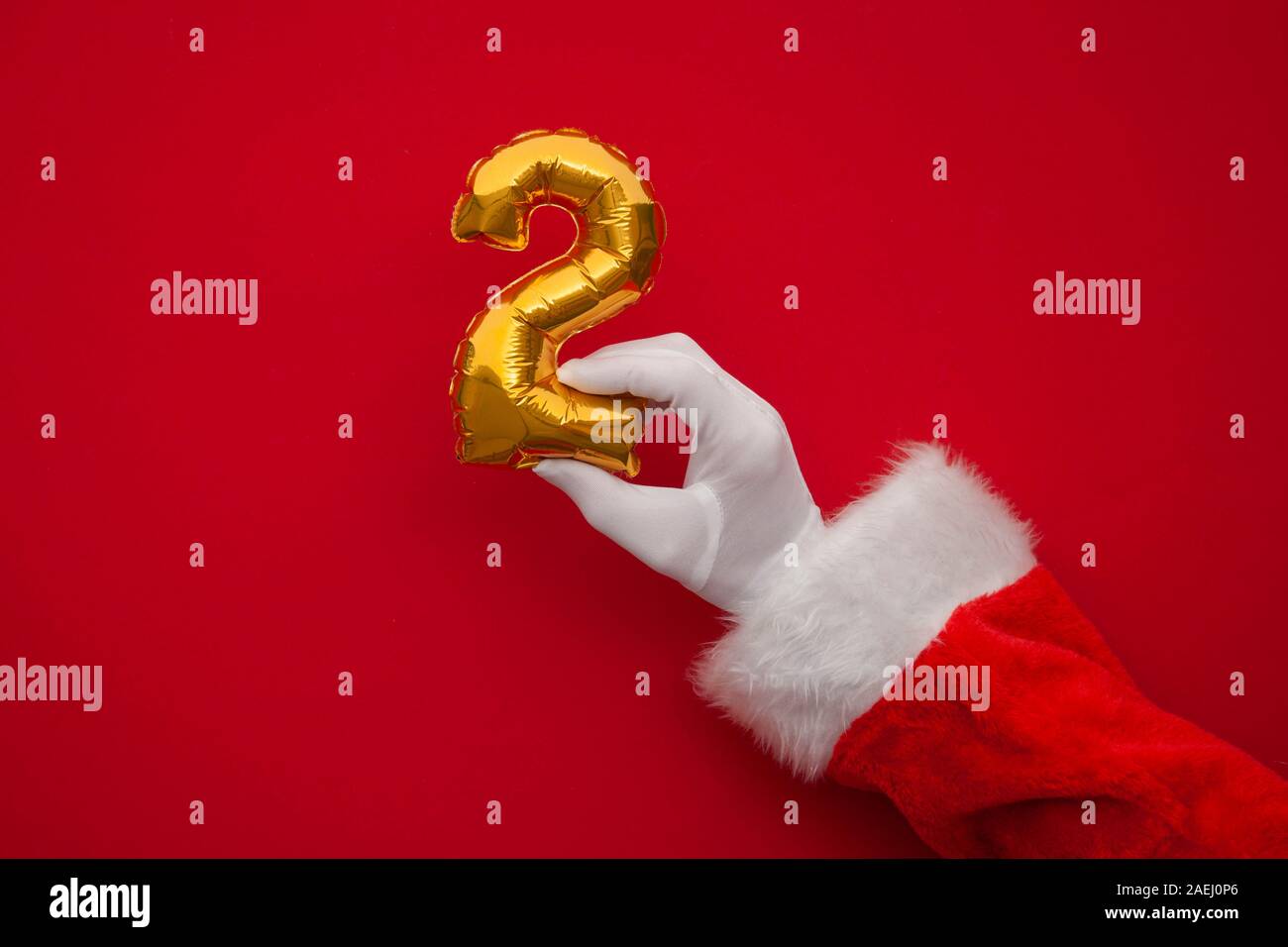 12 jours de Noël. Santa hands holding 2ème jour ballon sur fond rouge Banque D'Images