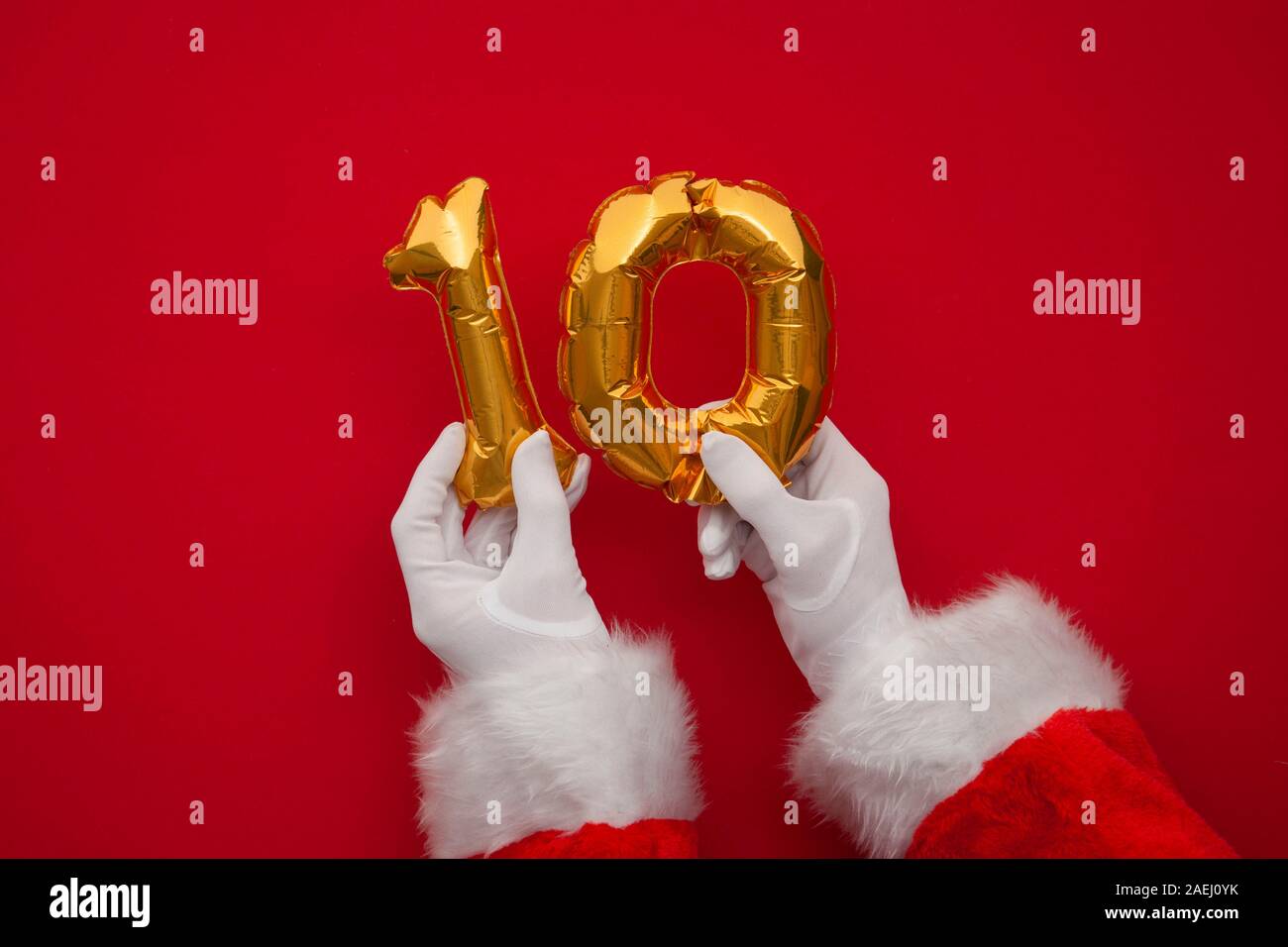12 jours de Noël. Santa hands holding 10e jour ballon sur fond rouge Banque D'Images